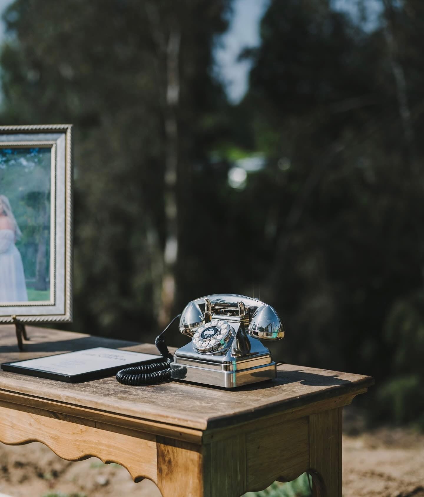 Vintage-style phone on a wooden table with a blurred natural background