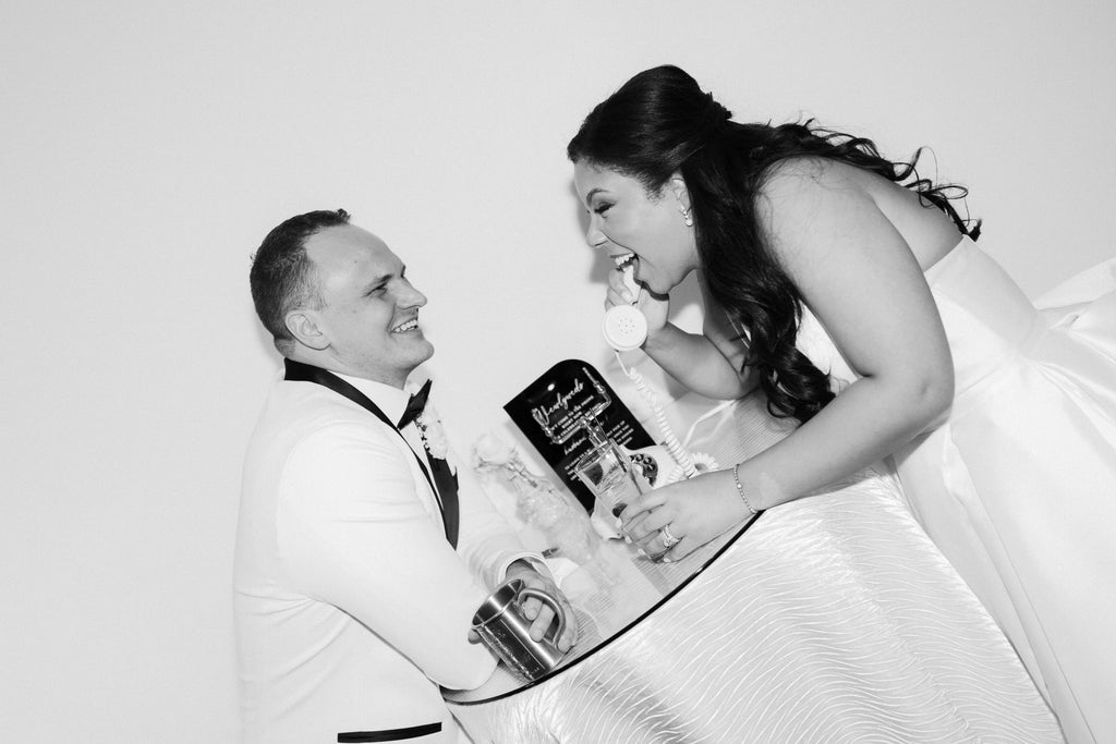 Black and white photo of a couple in formal attire with a book or magazine.