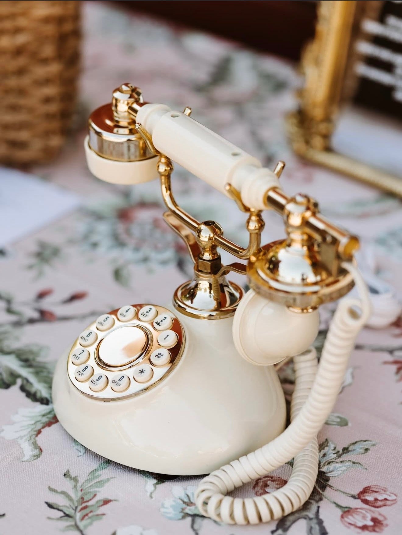 Vintage-style phone with gold accents on a floral-patterned surface